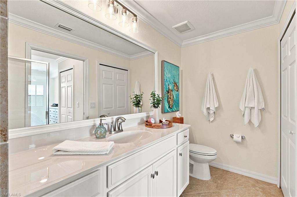 Bathroom with a long white vanity, large mirror, and turquoise sea-turtle artwork.