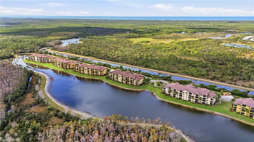 Aerial view of lakeside condominium buildings beside wetlands and winding waterways.
