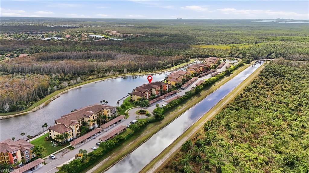 Aerial view of Trevi Court homes beside a lake and canal, with a red pin marking one residence.