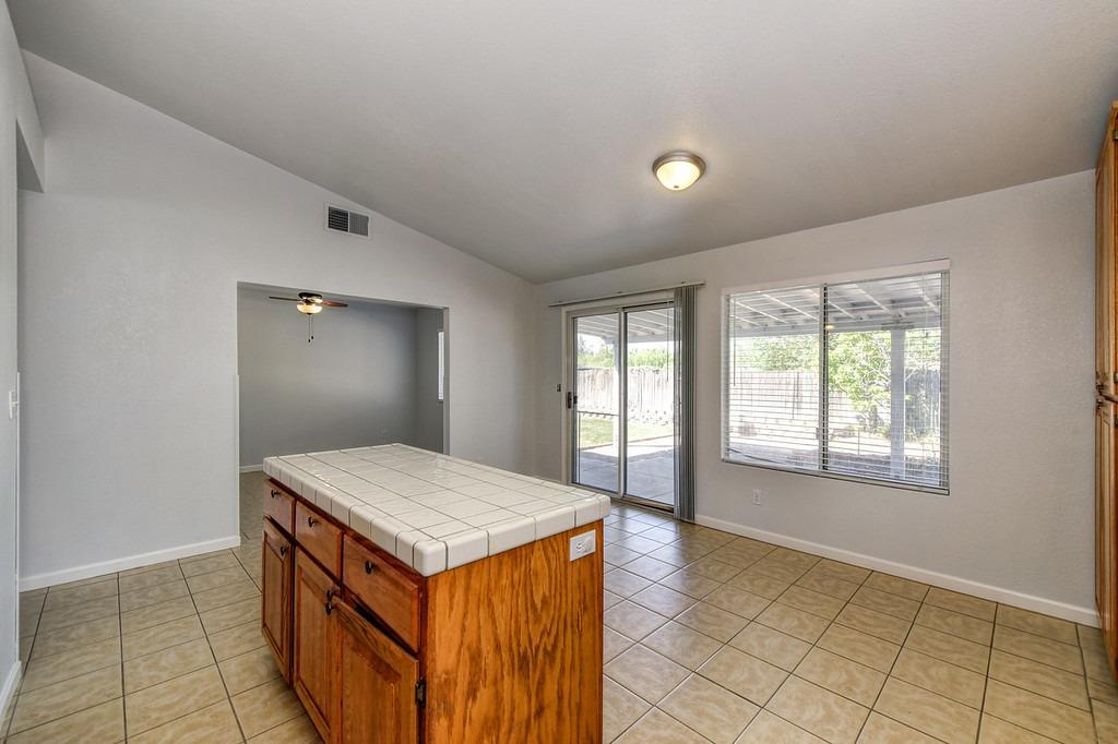 Vacant kitchen with a tiled wood island and sliding glass door to a covered patio.