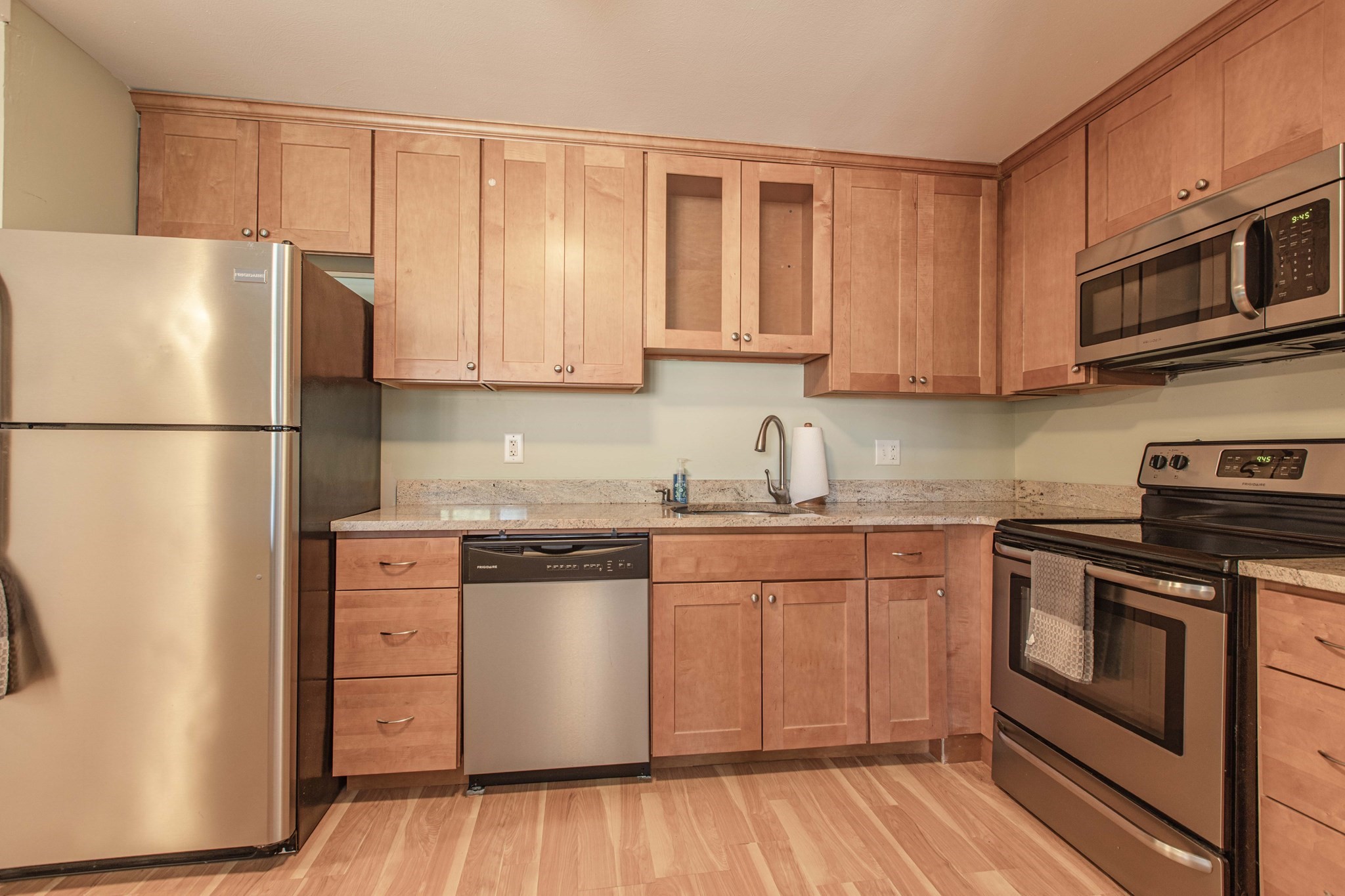 Kitchen with wood cabinets, granite counters, and stainless steel appliances.