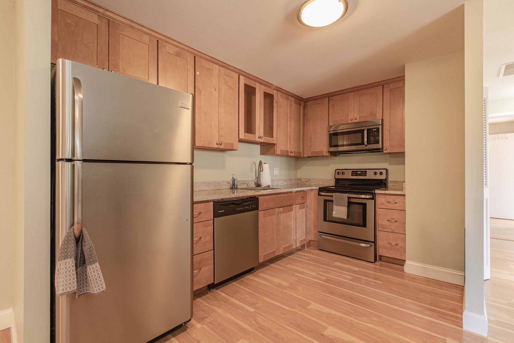 Kitchen with wood cabinets, granite counters, and stainless steel appliances.