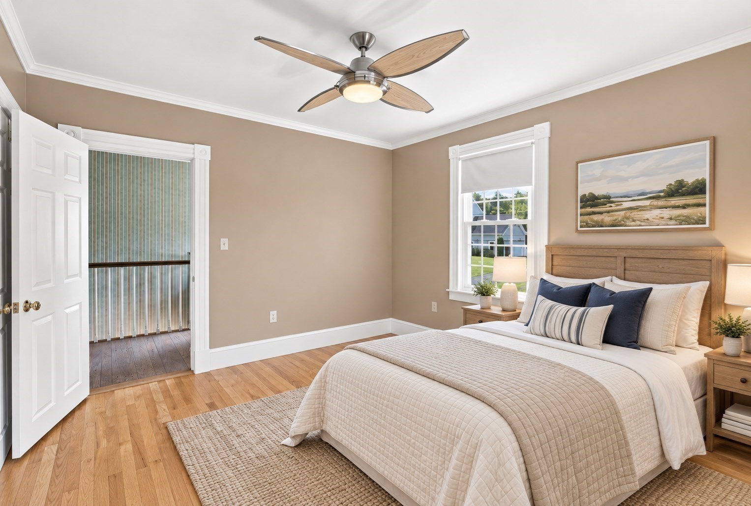 Staged bedroom with a wood-framed bed, hardwood floors, ceiling fan, and window overlooking the yard.