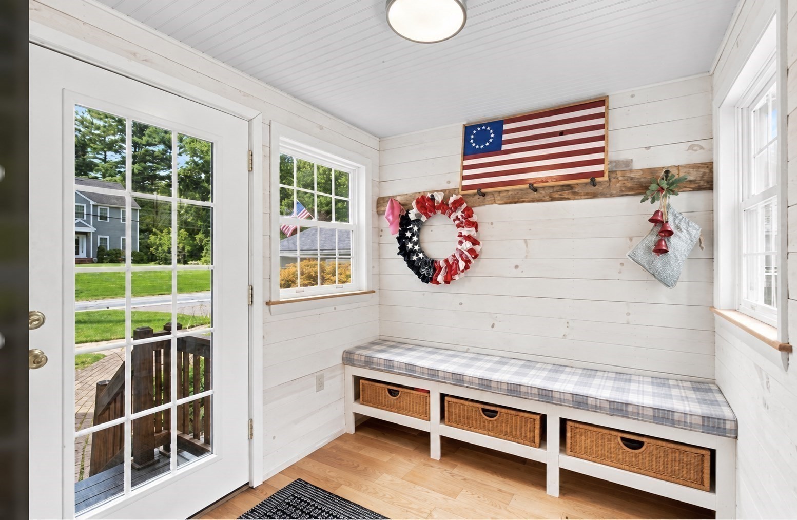 Mudroom with a built-in bench, wicker baskets, and patriotic wall decorations