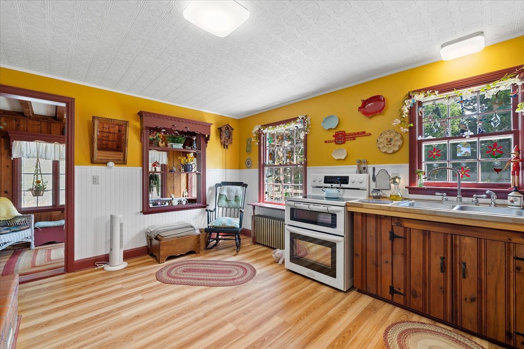 Kitchen with mustard-yellow walls, dark wood cabinets, and a sink beneath a large window.