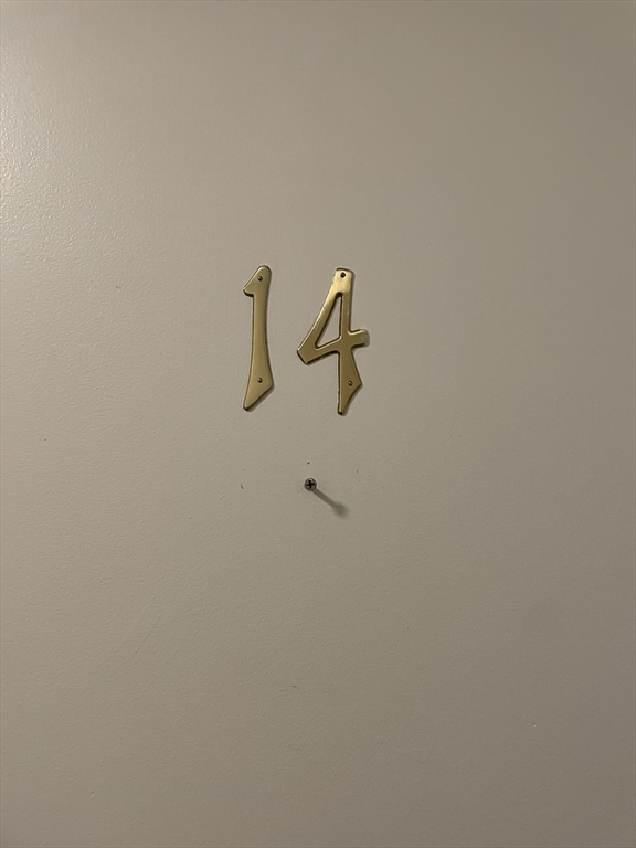 Unit door marked 14 with brass numerals above a peephole.