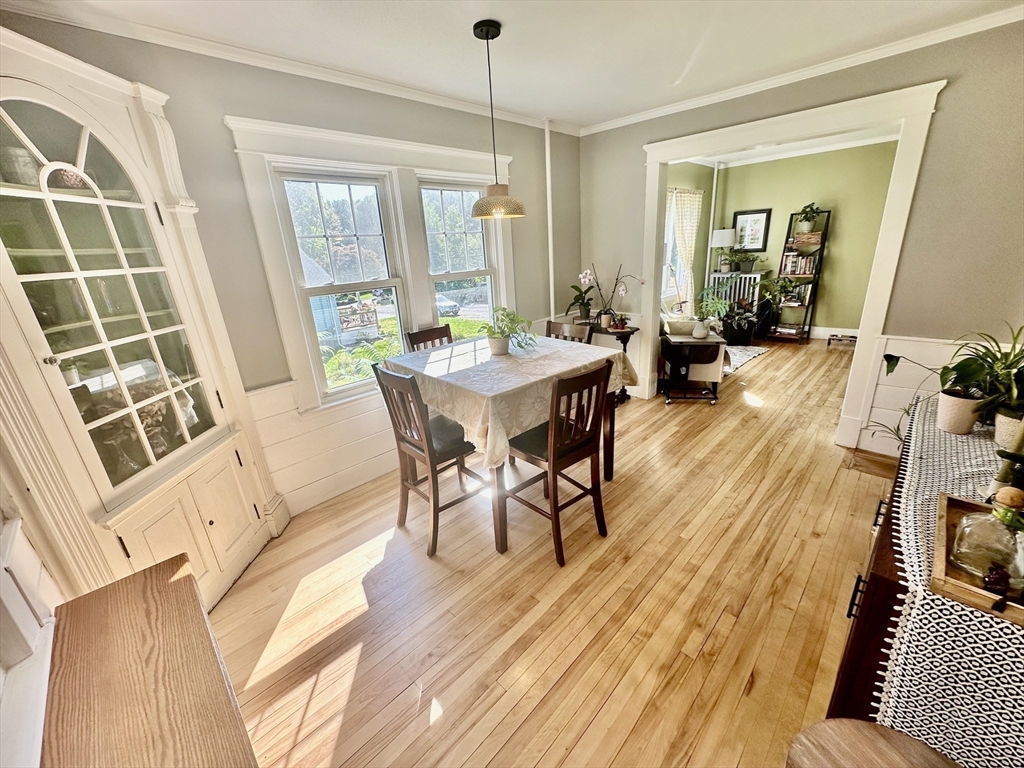 Dining room with a built-in china cabinet, tall windows, and polished hardwood floors.