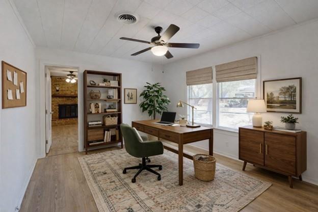 Home office with a wooden desk, green swivel chair, bookcase, and large windows.
