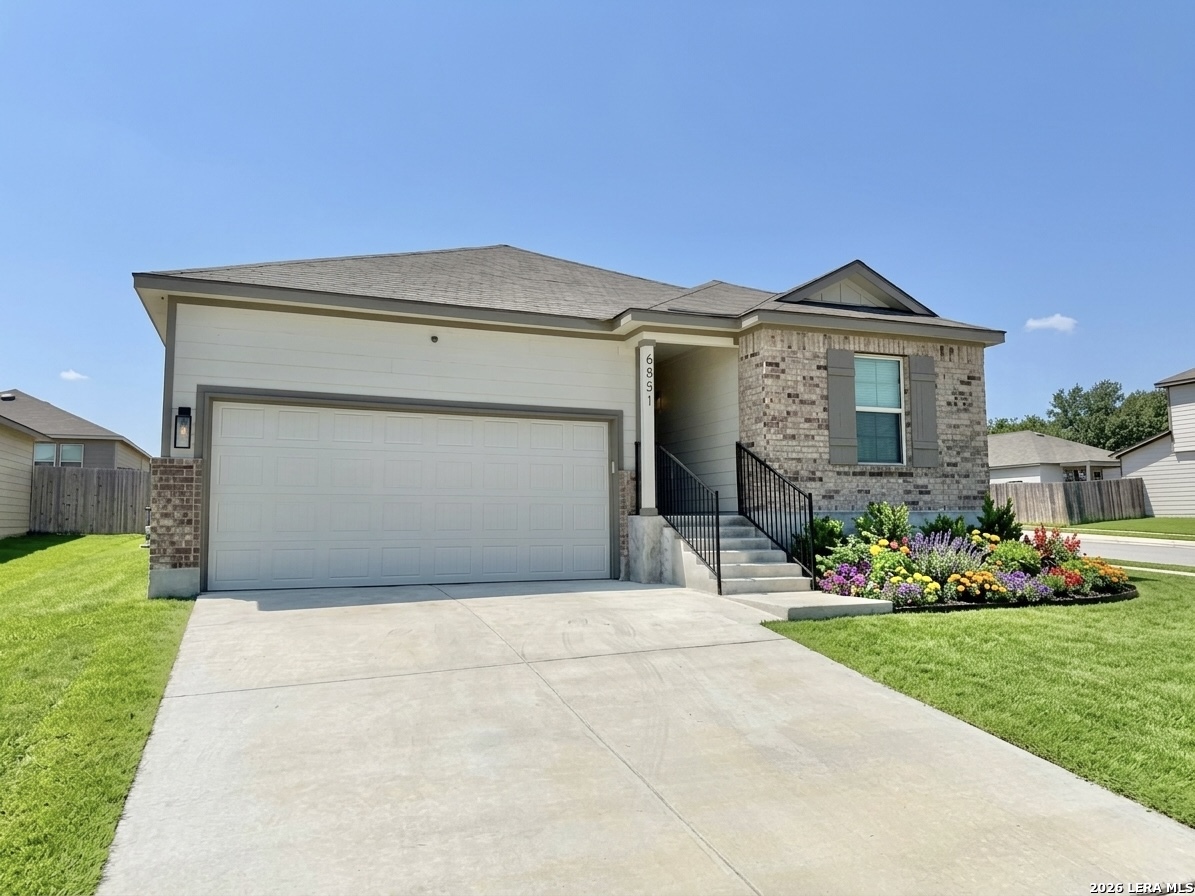 House at 6851 Titan Park with a two-car garage and colorful front flower bed.