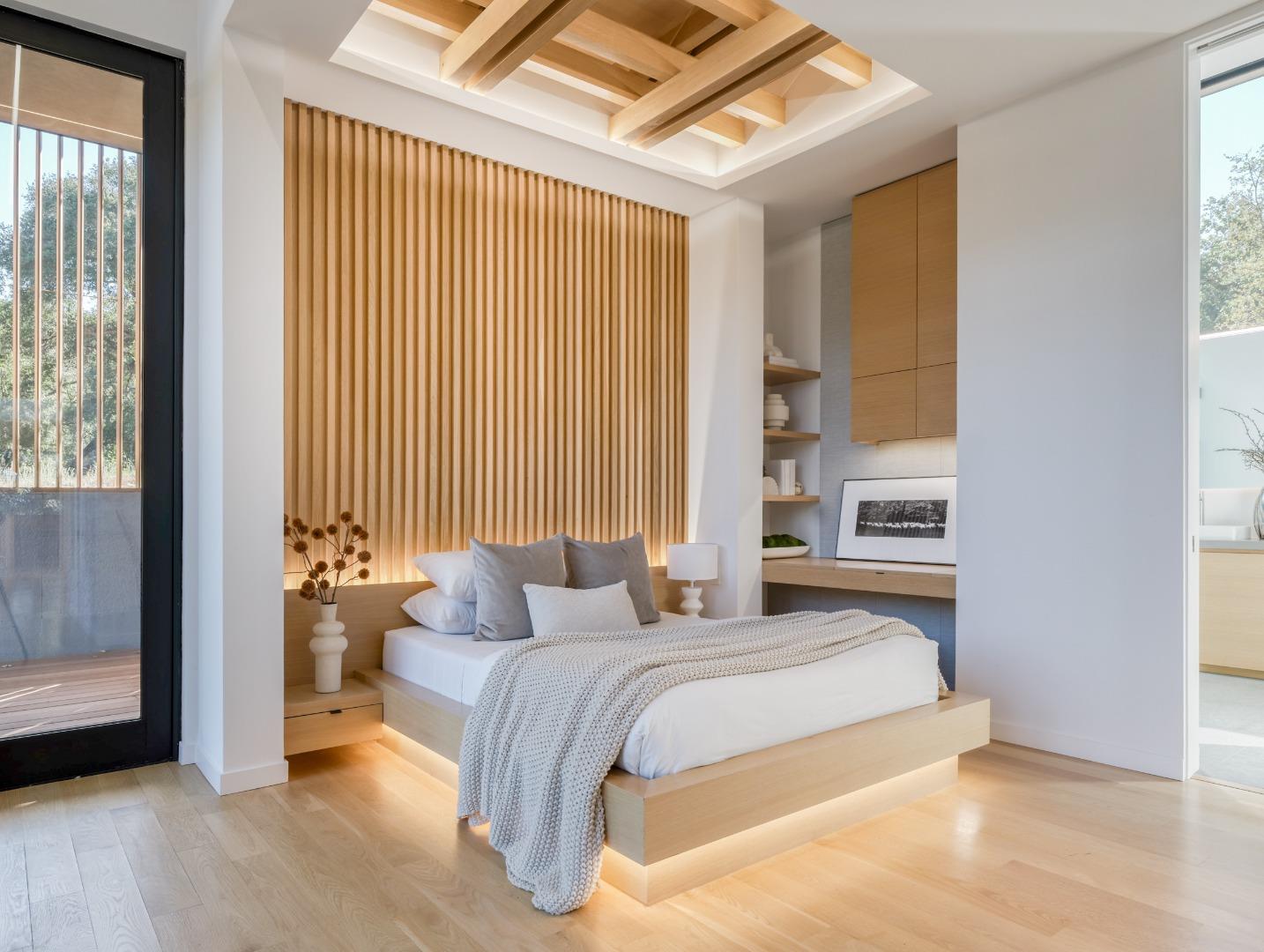 Bedroom with a low platform bed, wood-slat feature wall, and exposed ceiling beams.