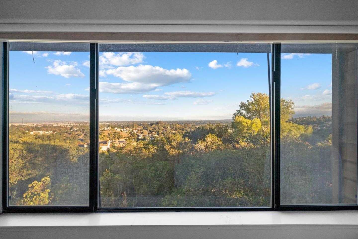 Wooded hills and scattered homes viewed through wide sliding windows.