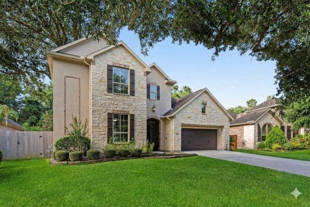 Two-story stone-and-stucco house with dark shutters, an attached garage, and a broad green lawn.