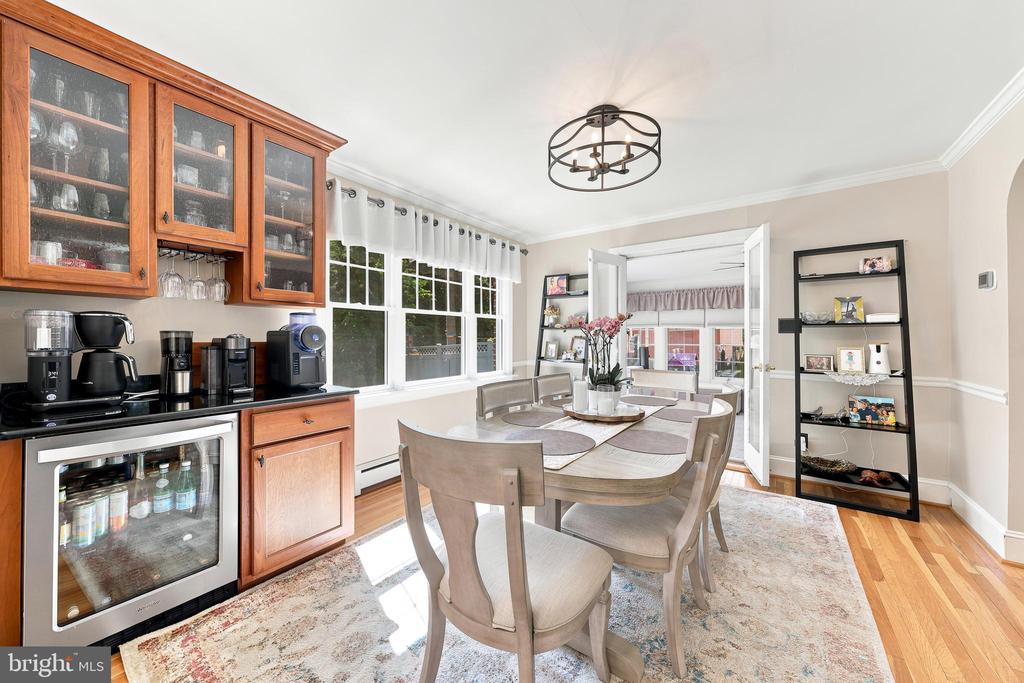 Dining area with an oval table, large windows, and a built-in beverage cabinet.