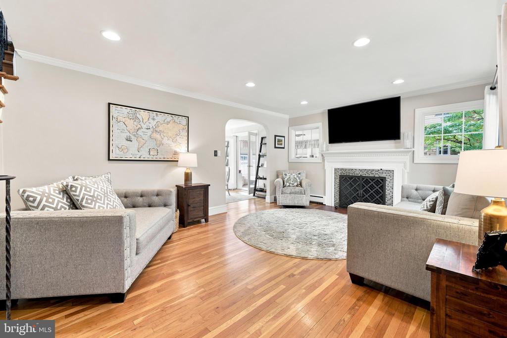 Living room with hardwood floors, gray sofas, a fireplace, and a wall-mounted television.