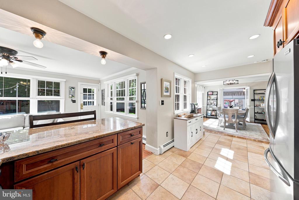 Open kitchen with a wood island and granite countertop, looking through to the dining area.