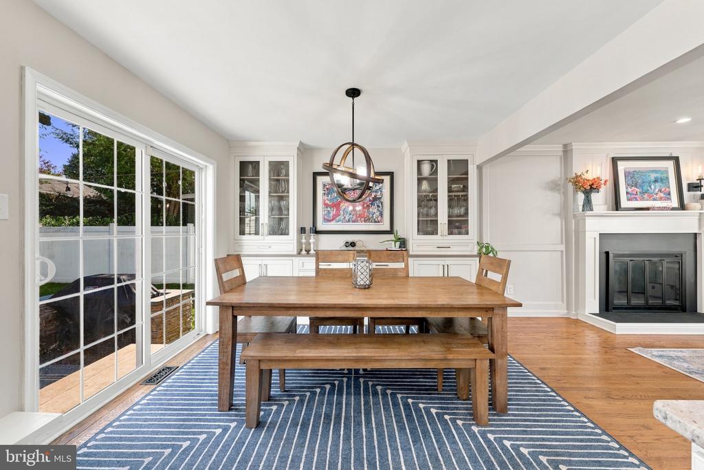 Dining room with a wooden table, built-in display cabinets, and a fireplace.