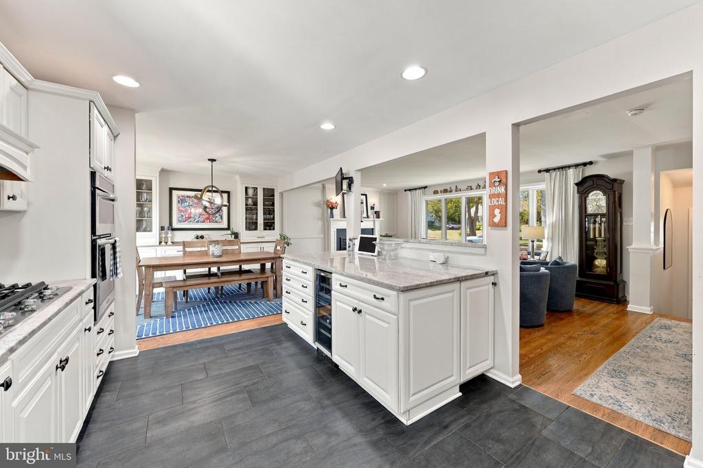 Bright kitchen with a large island opening to a dining area and living room.