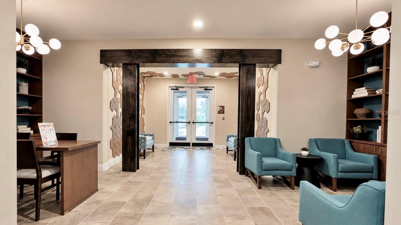 Building lobby with teal armchairs, a wood reception desk, and a decorative archway.