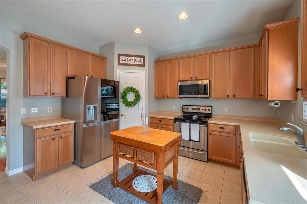 Kitchen with warm wood cabinets, stainless steel appliances, and a butcher-block island.