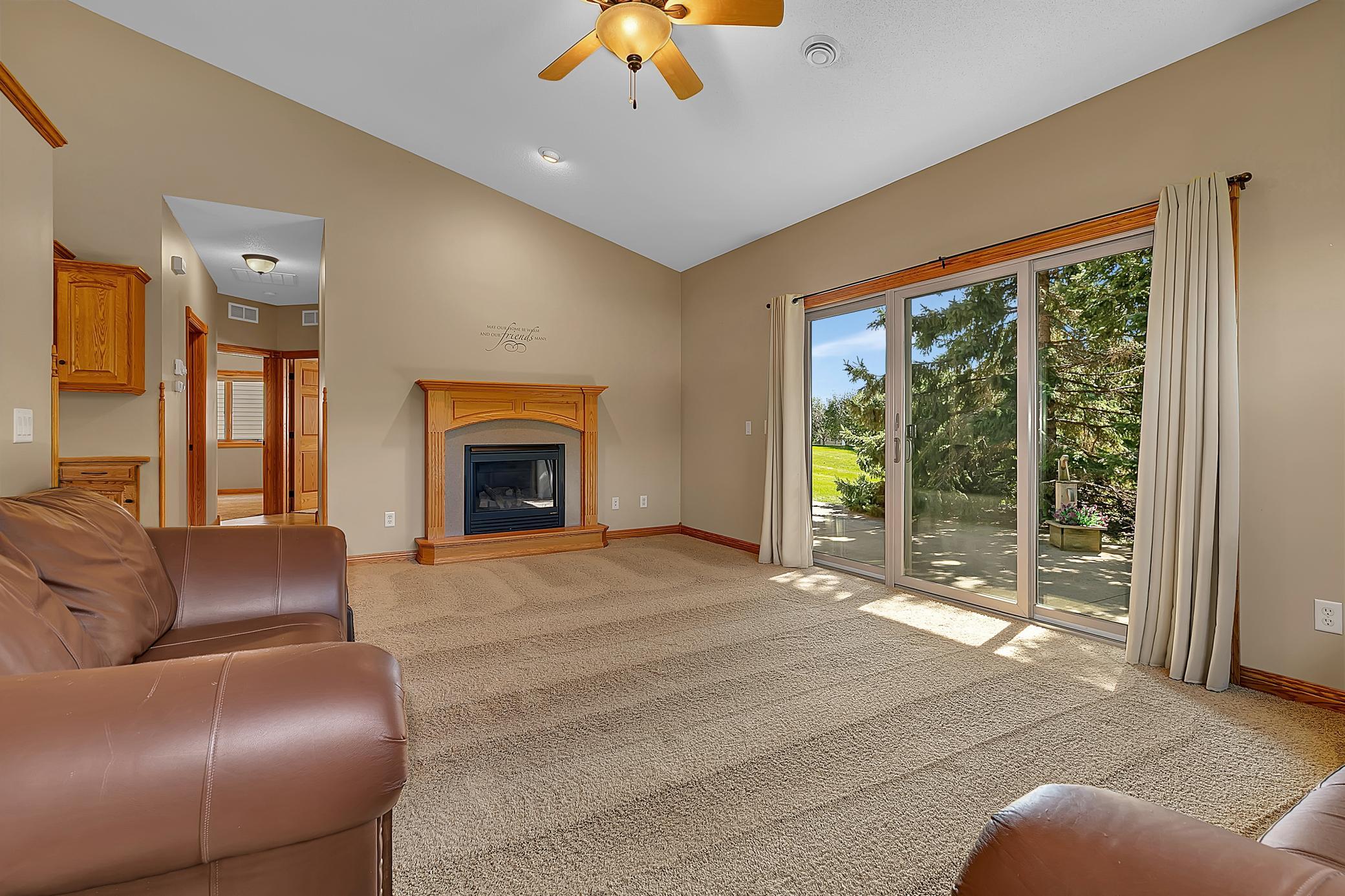 Living room with a wood-trimmed fireplace and sliding glass doors opening to a patio.