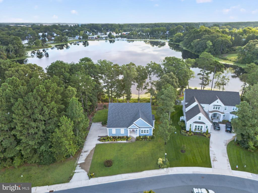 Two homes beside a tree-lined lake, viewed from above.
