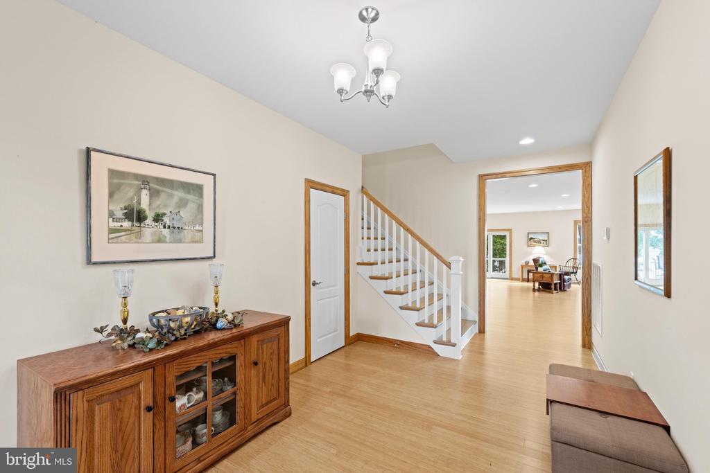 Entry hall with a wood console cabinet, staircase, and doorway to the living room.