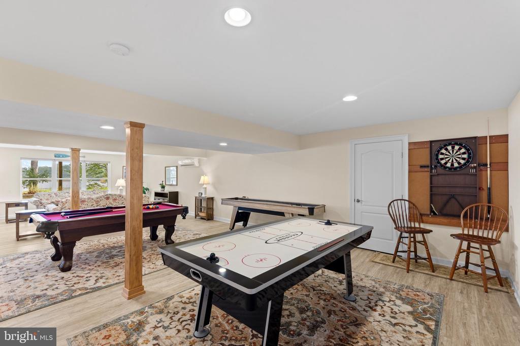 Recreation room with a pool table, air hockey table, and dartboard.
