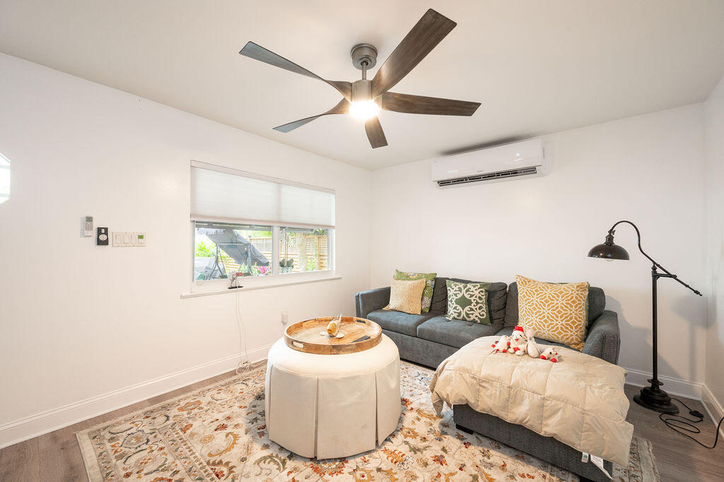 Living room with a gray sofa and chaise, round coffee table, patterned rug, and ceiling fan.