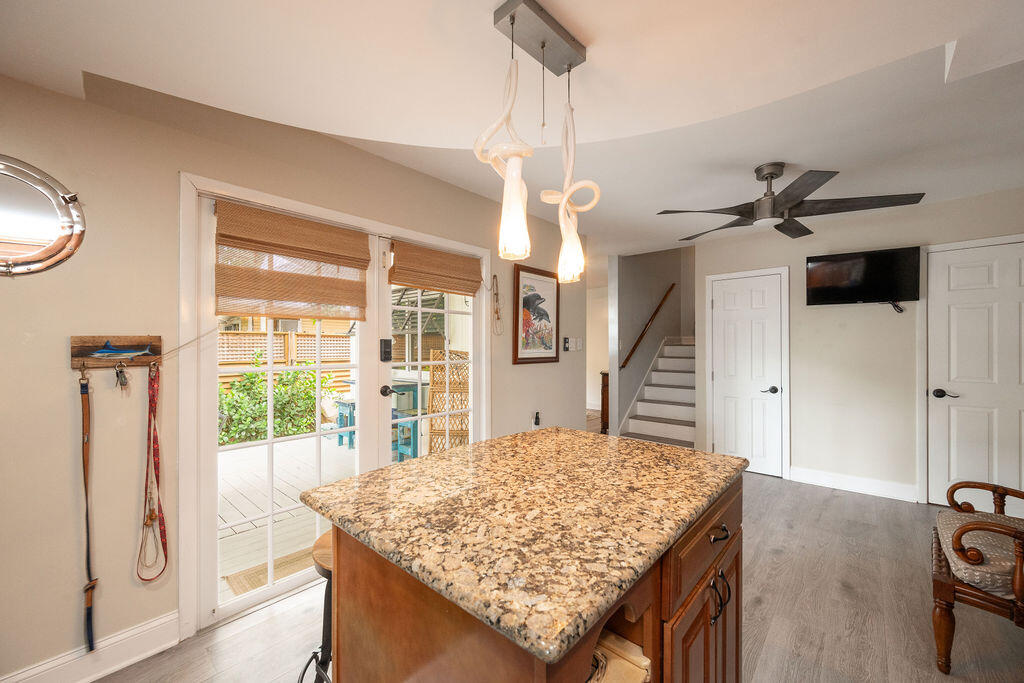 Kitchen with a granite-topped island, wood cabinetry, and sliding glass doors to a deck.