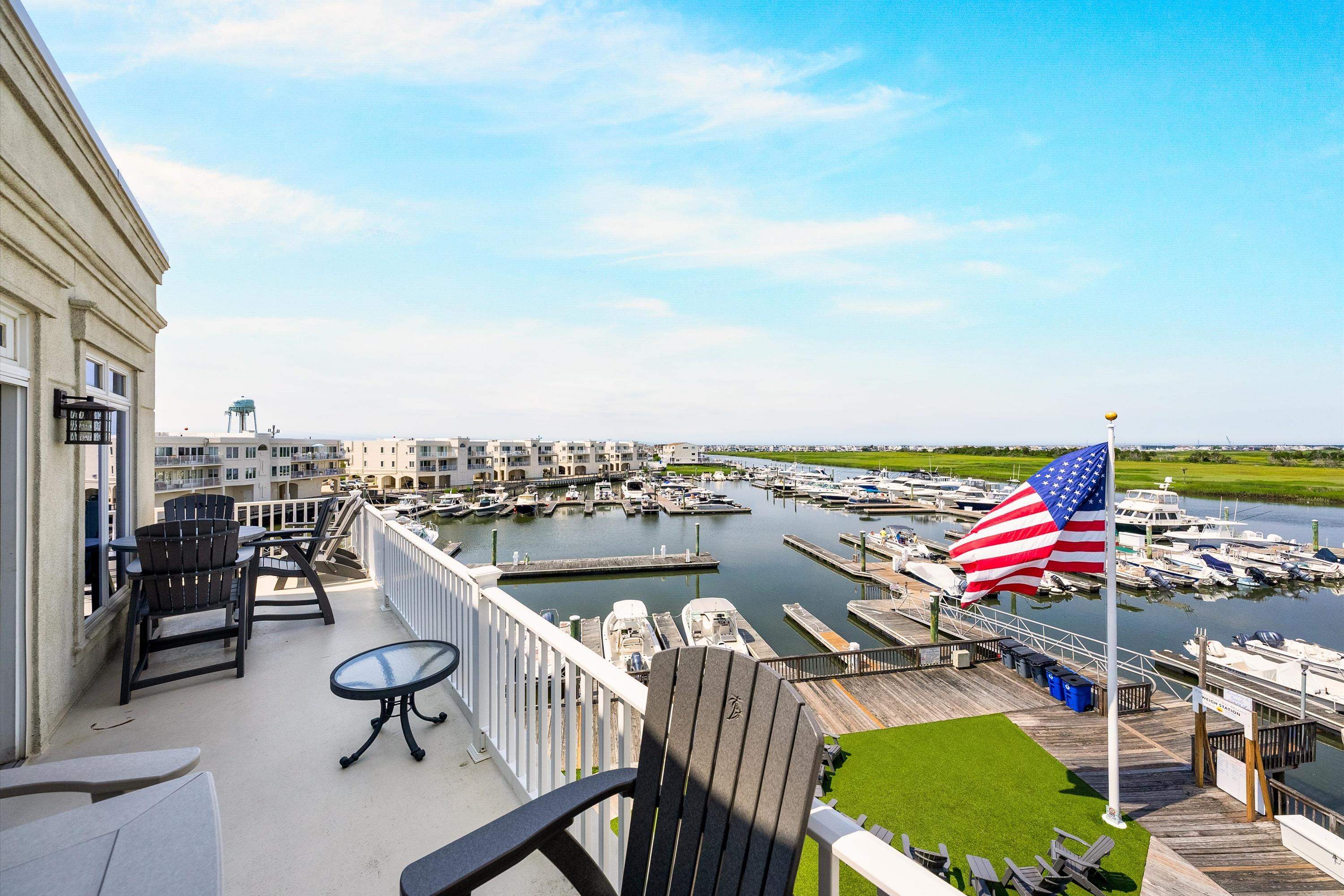 Condominium balcony overlooking a marina, with boats and an American flag.
