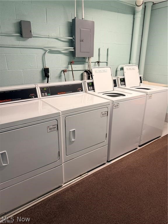 Laundry room with a row of dryers and top-loading washing machines.