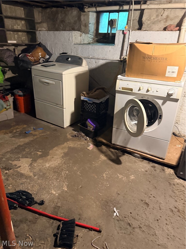 Basement laundry area with an open front-loading washer beside a top-loading dryer.