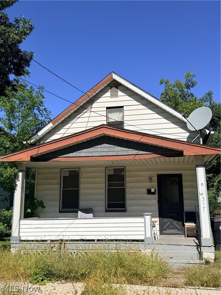 Two-story white-sided house with a red-trimmed porch roof and satellite dish.