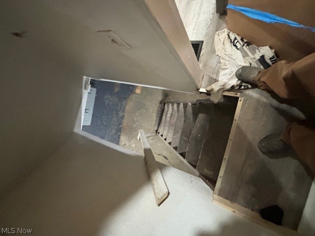 Unfinished stairwell with exposed framing and construction materials.