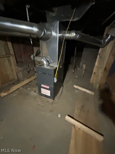 Basement furnace with exposed ductwork and unfinished framing.