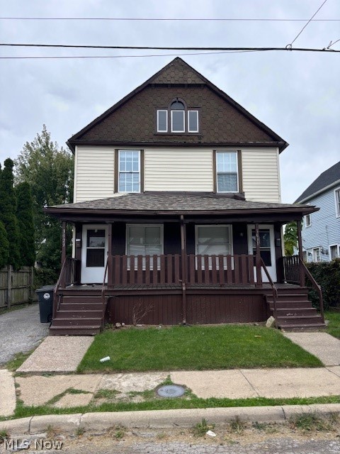 Two-story duplex with a deep covered porch, dark brown railing, and two front entrances.