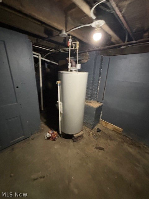 Basement utility area with a water heater, exposed ceiling pipes, and unfinished walls.