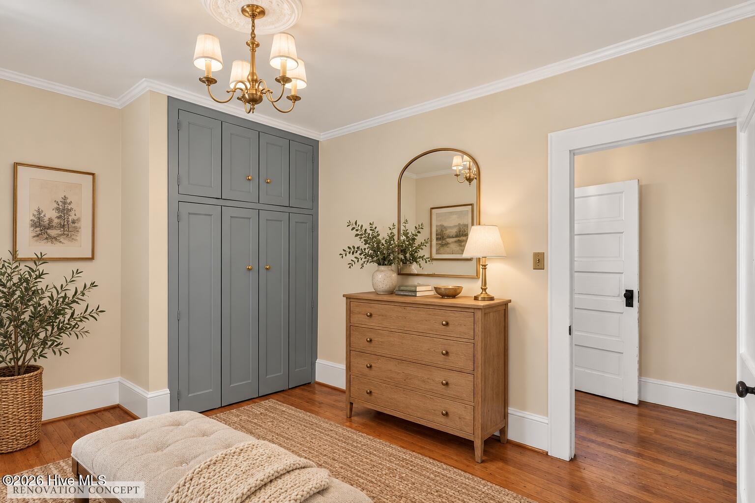 Bedroom with gray built-in cabinets, wooden dresser, arched mirror, and brass chandelier.