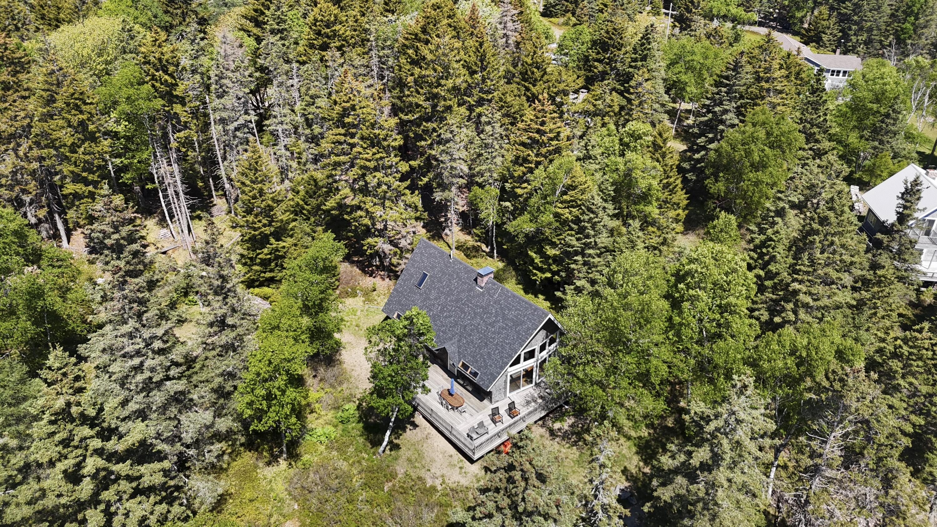 Wooded home with a large deck, seen from above