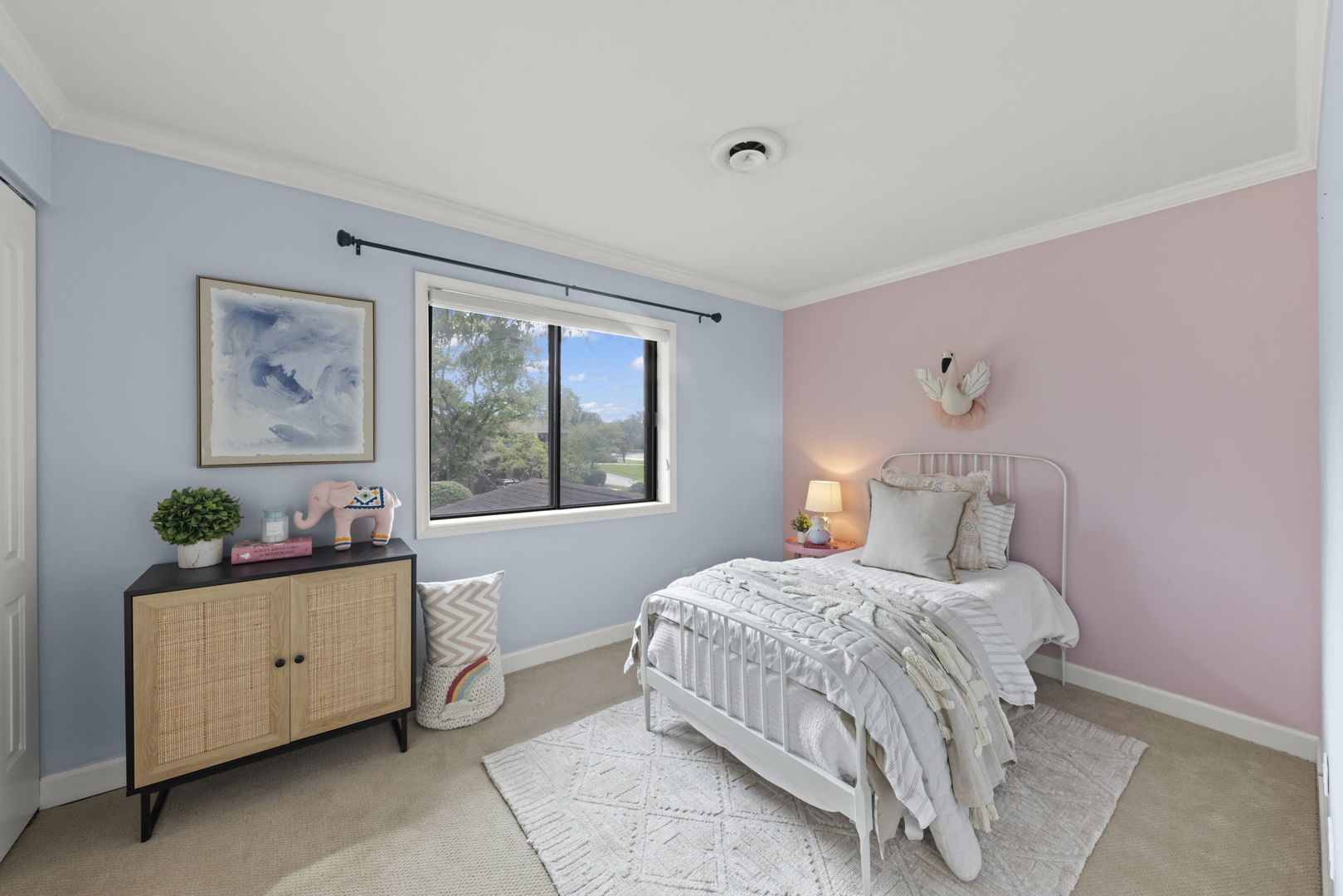 Bedroom with a white metal bed, pink and blue walls, and a large window.