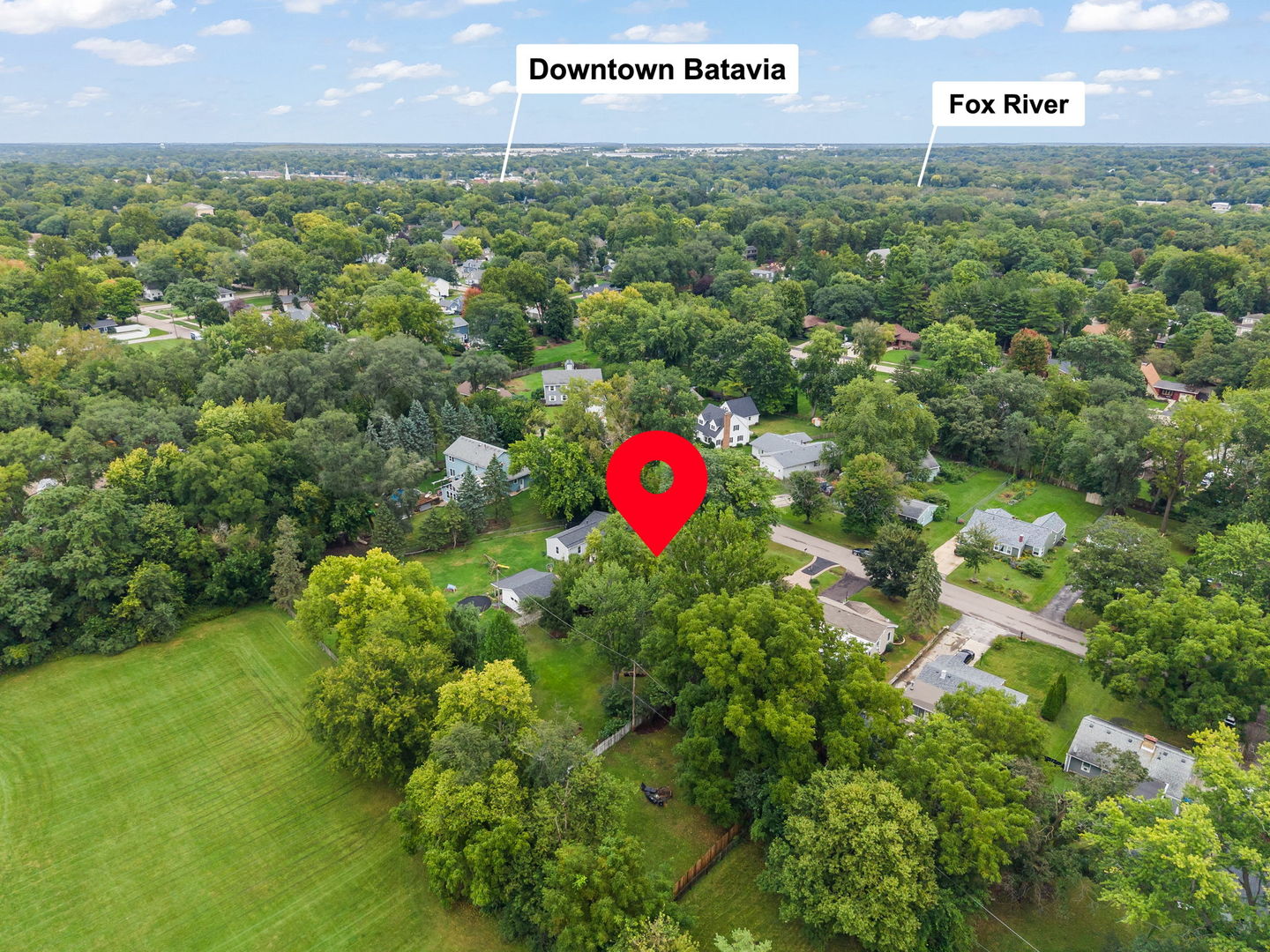 Aerial view of the tree-filled Batavia neighborhood, with a red pin marking the property.