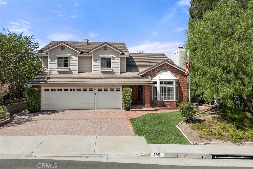 Two-story house with brick accents, a double garage, and a brick-paver driveway.