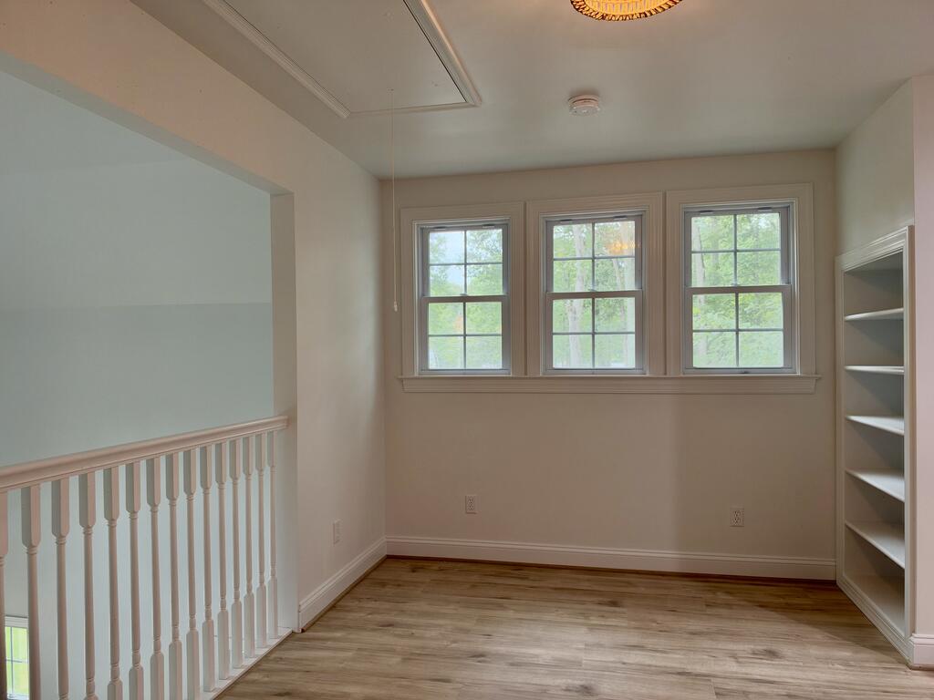Upstairs landing with three windows, built-in shelves, and a white stair railing.