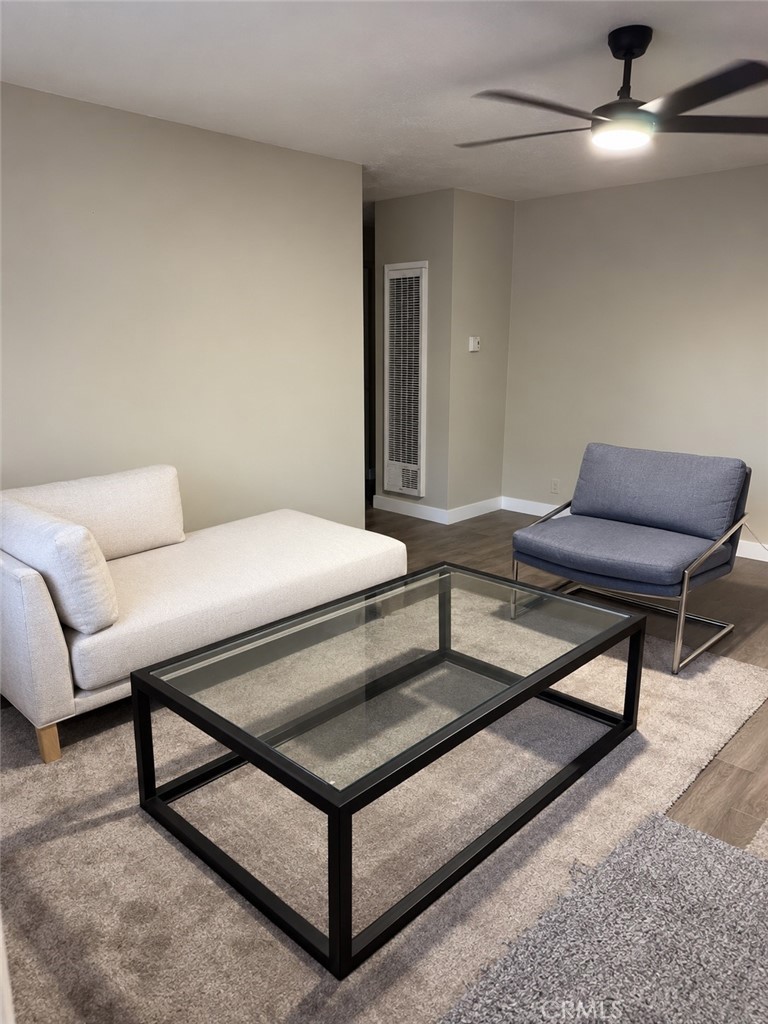 Living room with a cream sofa, blue chair, and black glass-top coffee table.
