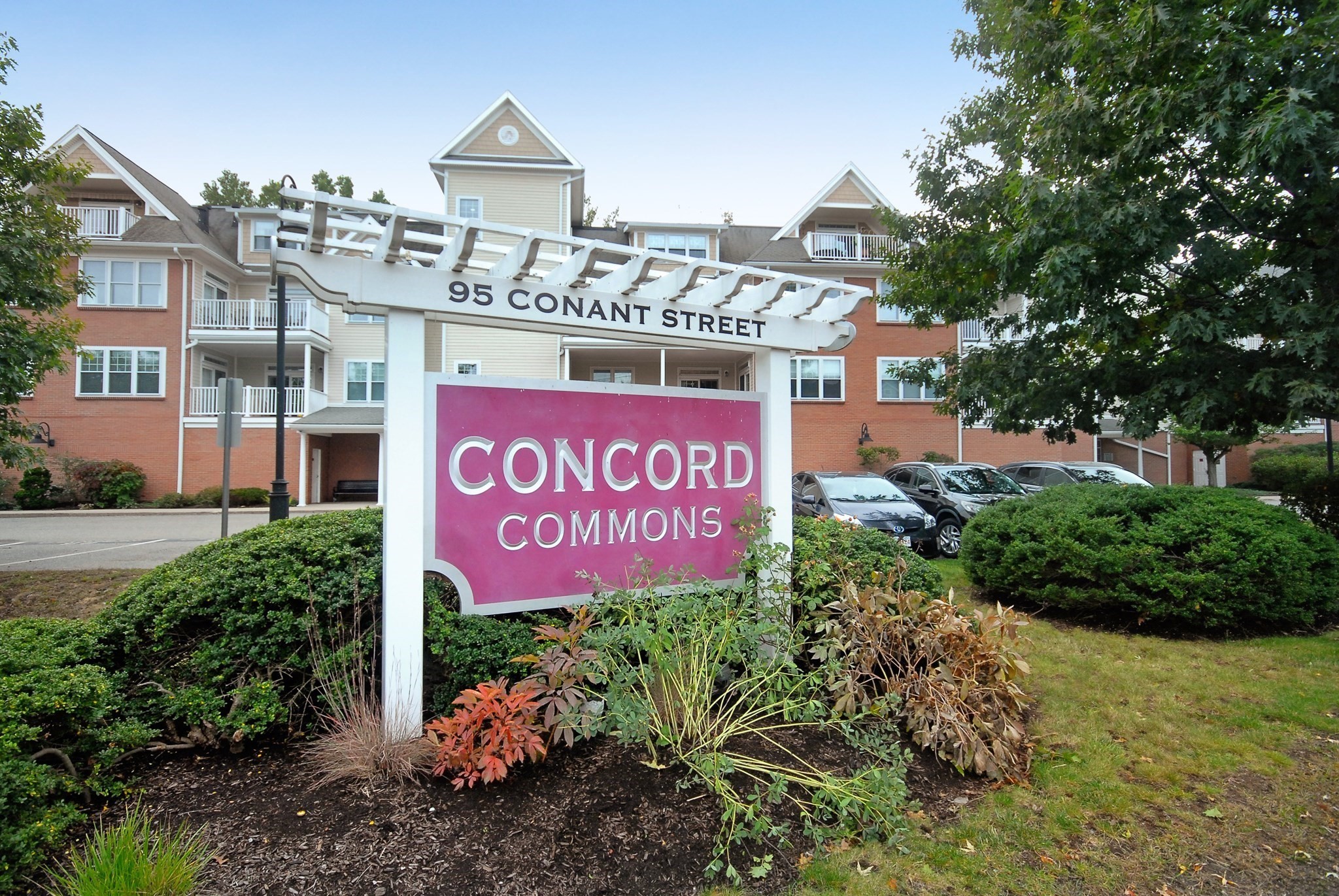 Concord Commons residential building behind its landscaped entrance sign at 95 Conant Street.