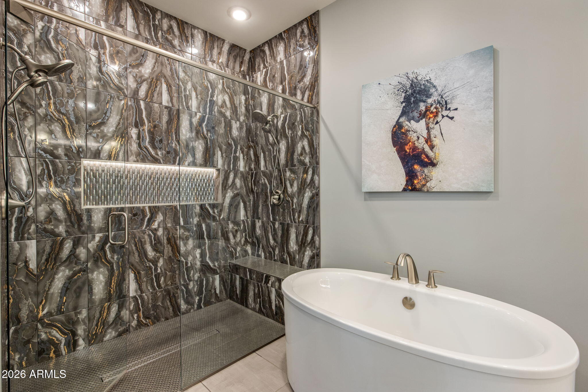 Bathroom with a white soaking tub beside a dramatic dark-tiled walk-in shower.