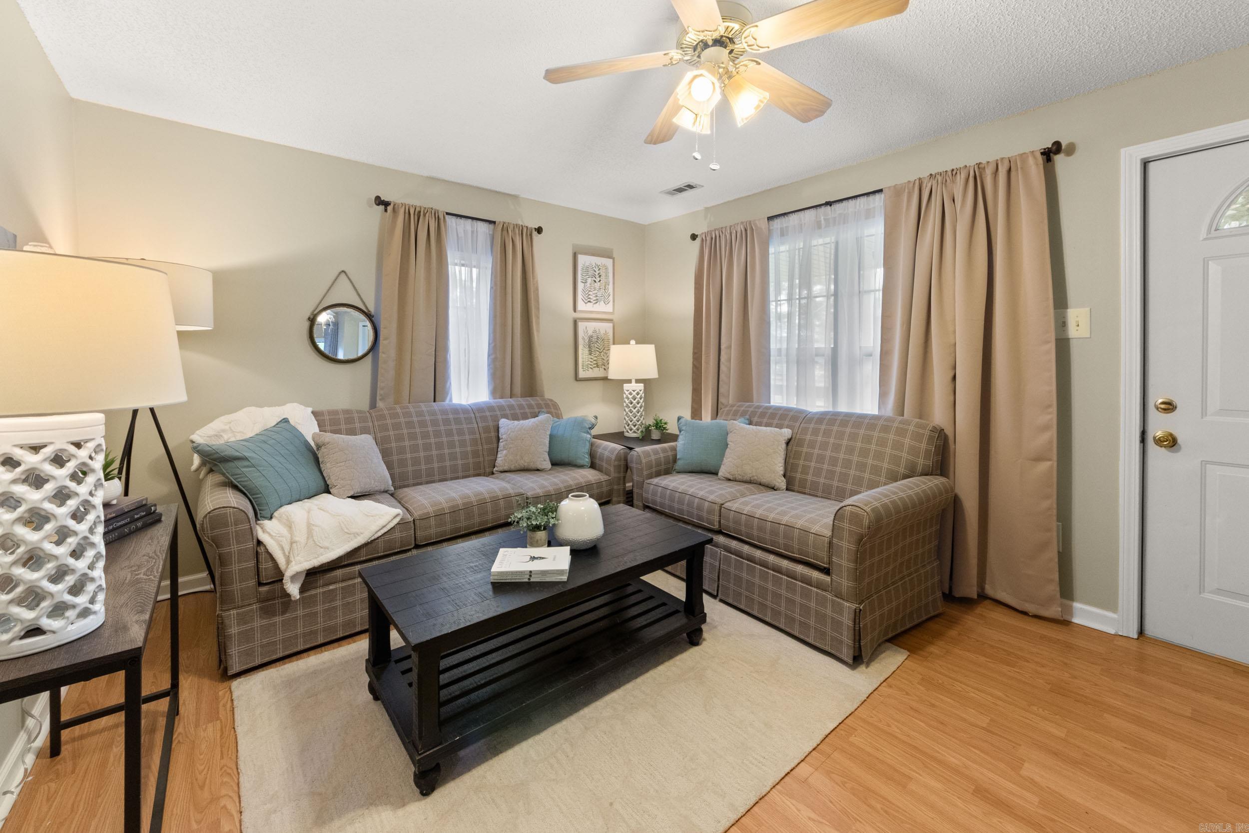 Living room with plaid sofas, blue pillows, and a black coffee table.