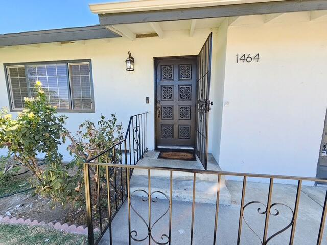 Home entrance with a dark paneled door, covered porch, and black metal railing.