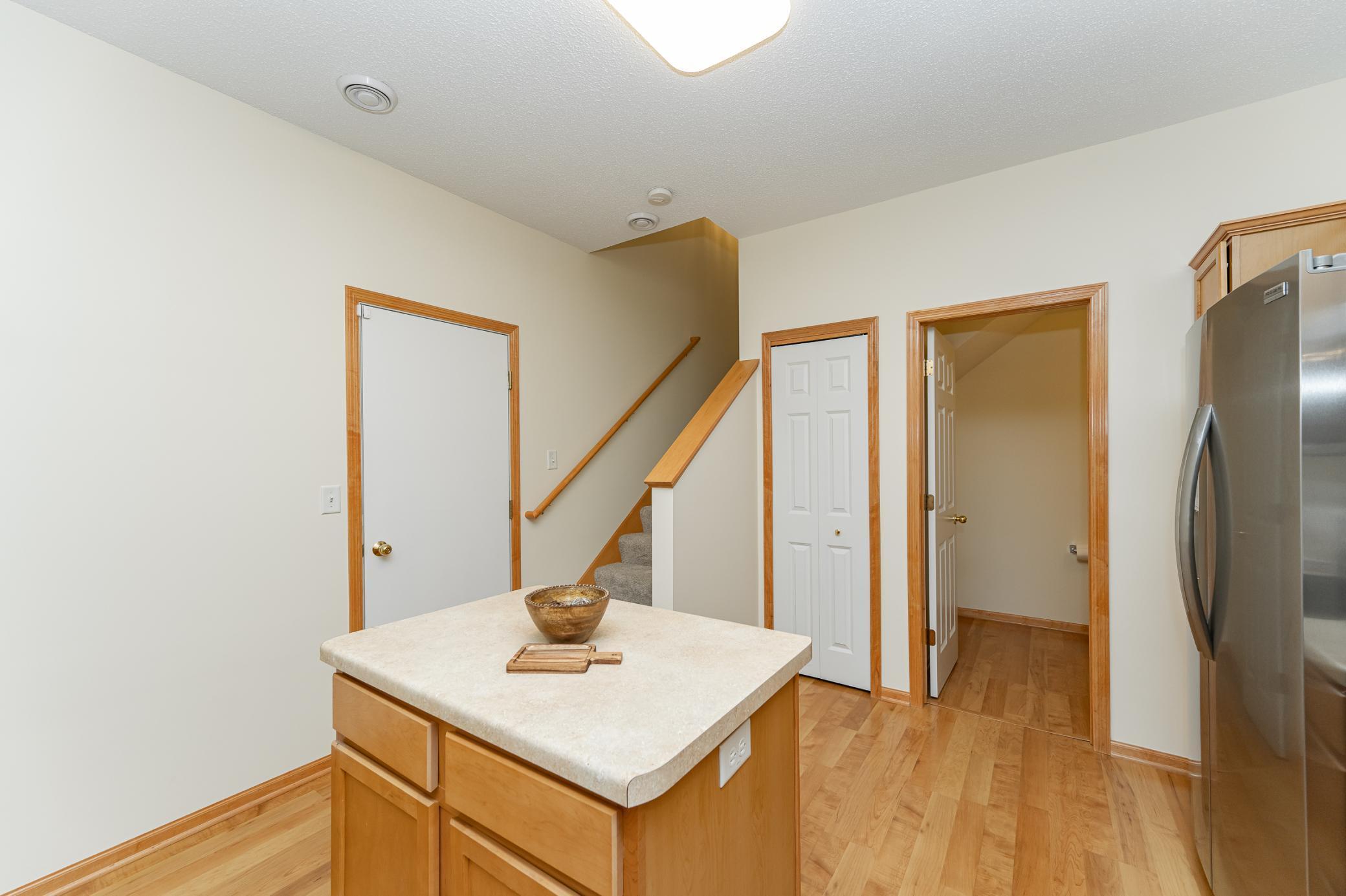 Kitchen with a wood island, light countertop, and stainless steel refrigerator.