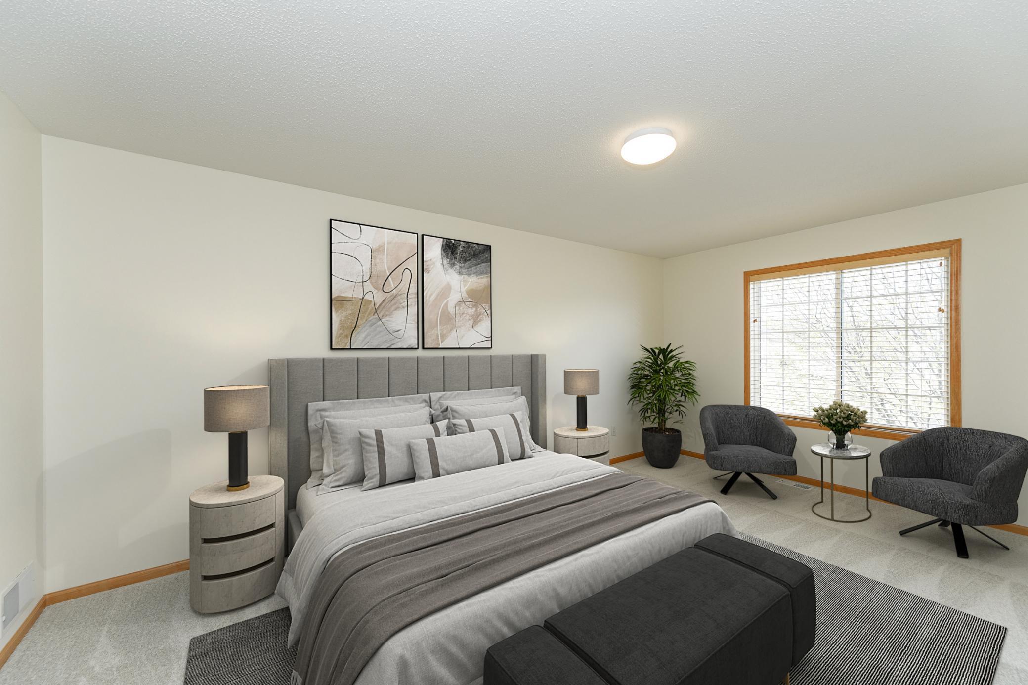 Staged bedroom with a gray bed, abstract wall art, and a window-side seating area.